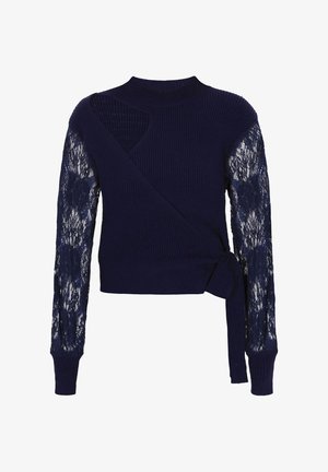 Maglione blu navy con corpo in maglia rigata e manica sinistra in pizzo. Presenta un design avvolgente e un dettaglio in vita con fiocco.