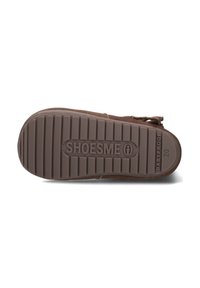 Bruine rubberen zool met verticale groeven, met de opdruk "SHOESME" en "BABYPROOF" tekst, met een afgeronde vorm en stevige constructie.