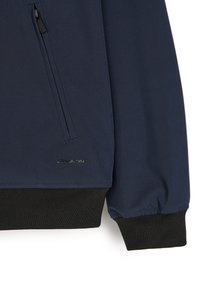 Granatowa kurtka wykonana z gładkiego materiału, z prążkowanymi czarnymi mankietami i boczną kieszenią na zamek. Zawiera małe srebrne logo na dolnym wykończeniu.