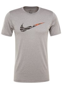 Camiseta Nike gris hecha de un tejido suave y transpirable. Presenta un gran logotipo de swoosh negro y naranja en la parte delantera, cuello redondo y mangas cortas.