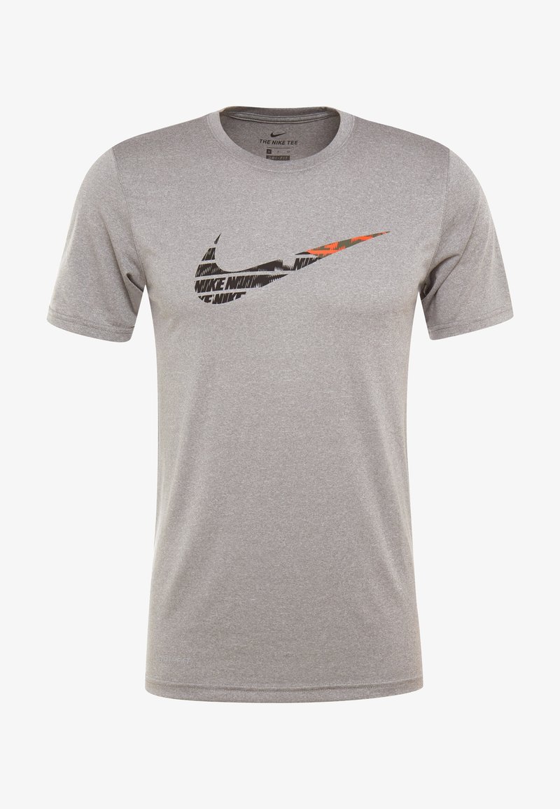 Camiseta Nike gris hecha de un tejido suave y transpirable. Presenta un gran logotipo de swoosh negro y naranja en la parte delantera, cuello redondo y mangas cortas.