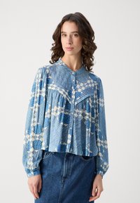 Blå mønstret bluse med kragehals, knappefront og lange puffede ermer. Laget av lett stoff med teksturert design.