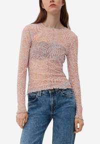 Langärmliges Oberteil mit einem hellorange-weißen Wellenmuster, aus leichtem Material gefertigt. Mit gerafftem Saum und rundem Ausschnitt.