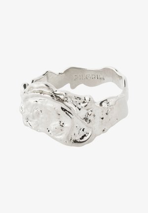 Geverfde zilveren ring met een organische vorm, voorzien van een golvende band en een ruwe oppervlakte. Gegraveerd logo aan de binnenkant van de band.