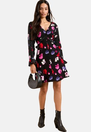 Schwarzes Blumenkleid mit langen Punktenärmeln, V-Ausschnitt, bunten Blumenmustern in Rosa- und Lilatönen und einer taillierten Taille.