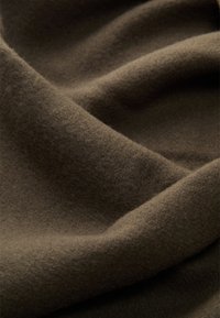 Tessuto marrone scuro, morbida texture, con pieghe leggere e una superficie liscia e opaca. Assenza di motivi o accessori visibili.