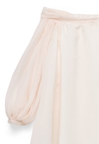 Bleg lyserød tynd bluseærme med rynket pufdesign og manchet, vist fra skulder til midt på arm på hvid baggrund.