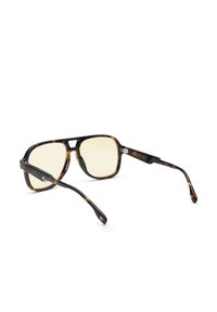 Zonnebril met oversized monturen in schildpadmotief, gele lenzen en zwart getextureerde pootjes met een steraccent.