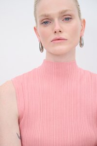 Roze ribben t-shirt zonder mouwen met een hoge hals, textuurstof en een gladde afwerking. Inclusief zilveren oorringen als accessoires.