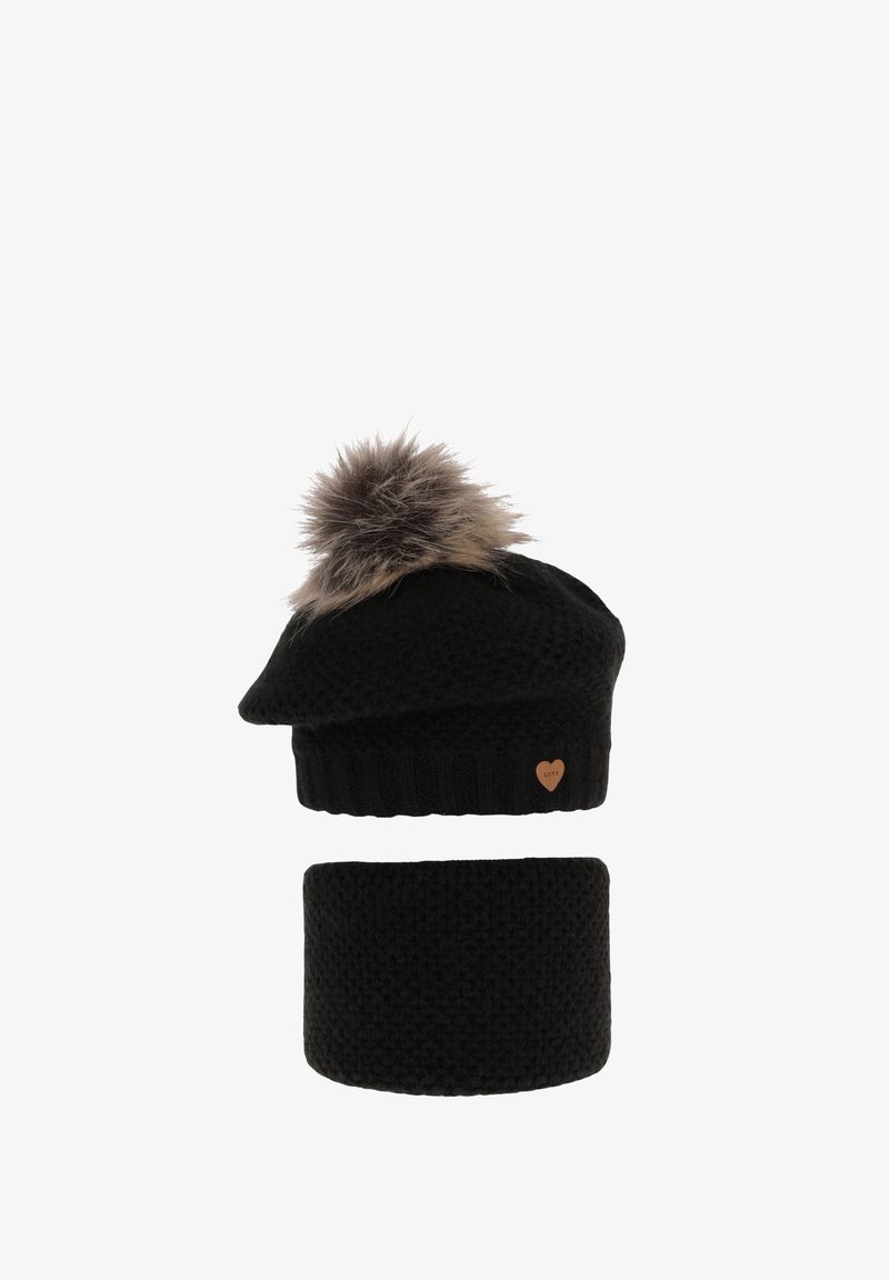Béret noir tricoté avec un pompon en fausse fourrure ; comprend un tour de cou tricoté noir assorti. Présente un accent en bois en forme de cœur.
