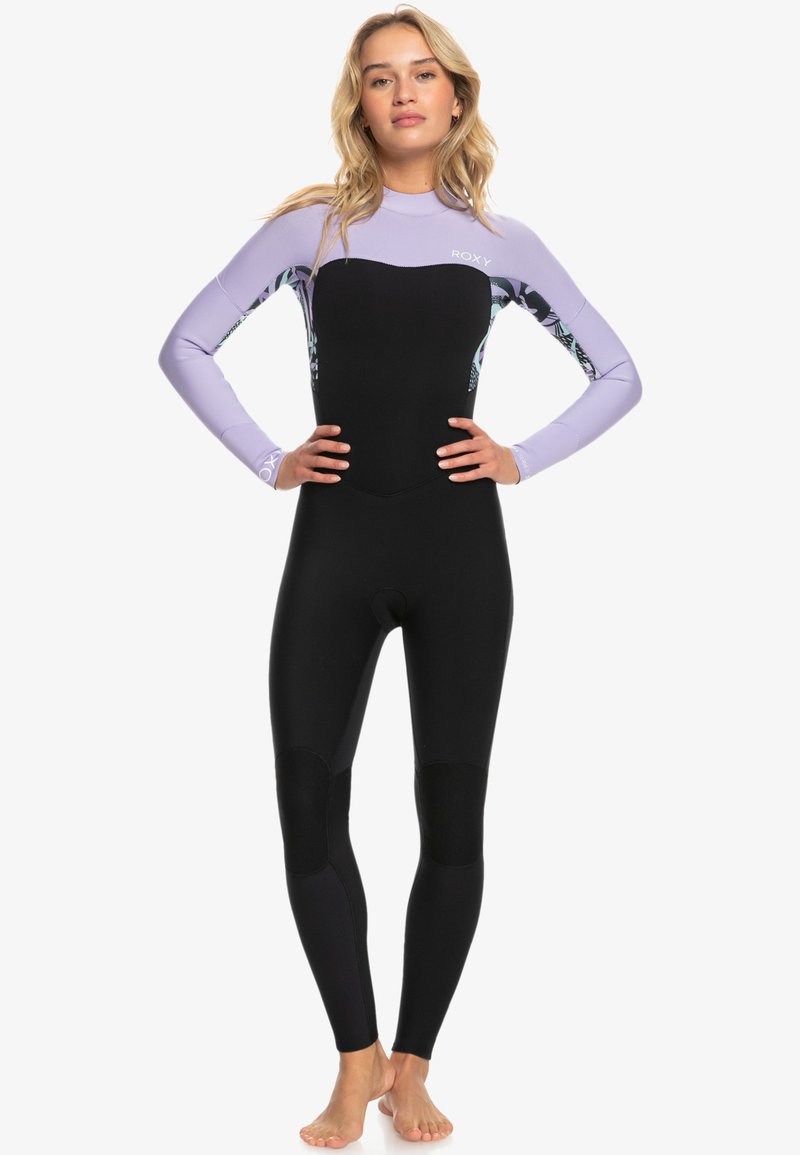 Koko badan wetsuit berwarna hitam dengan lengan lilac. Memiliki aksen berpola di sisi dan panel untuk fleksibilitas. Bahan halus dan dapat meregang.