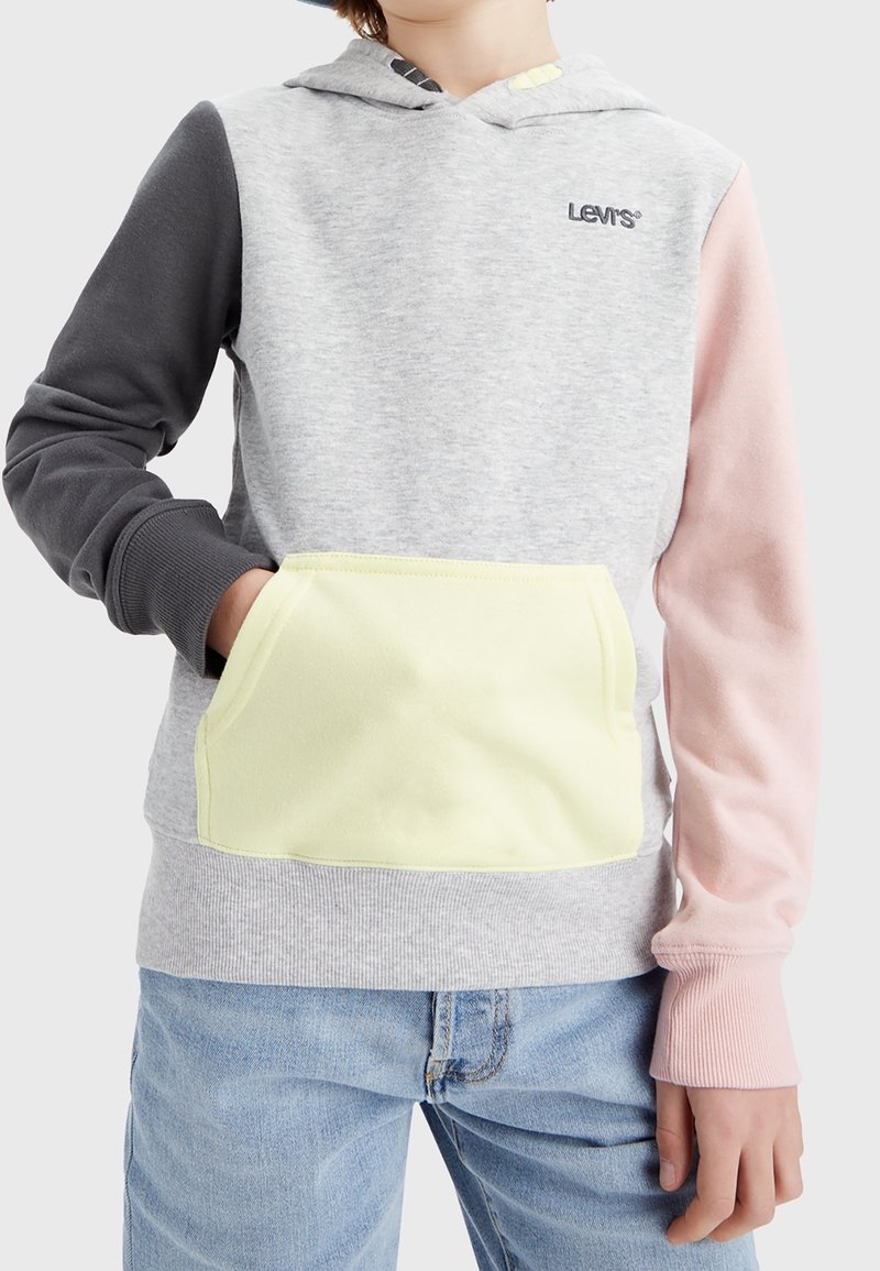 Hoodie Levi's con corpo grigio, maniche nere e rosa, e tasca gialla. Presenta un cappuccio con stringa e polsini a coste.