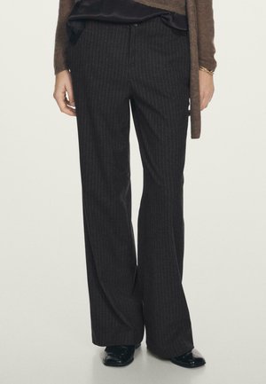 Schwarze, gestreifte Hosen mit weit geschnittenem Bein, aus einem weichen Stoff gefertigt, mit mittelhohem Bund und dezenten Fronttaschen.