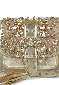 Bolso de mano dorado con intrincados adornos de gemas, patrones florales, acentos metálicos, superficie texturizada y un detalle de borlas.