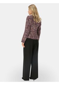 Marynarka tweedowa w kolorach purpurowym, różowym i kremowym, dopasowana w talii, w połączeniu z szerokimi czarnymi spodniami. Gładka tekstura, skrojony krój.
