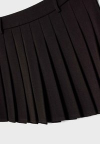 Czarna plisowana spódnica z paskiem w talii i szlufkami na pasek, ukazująca szczegółową fakturę materiału oraz strukturalne plisy na jasnym tle.