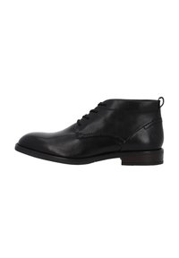 Stivali ankle in pelle nera con punta arrotondata, design con lacci, cuciture sottili e tacco piccolo. Presentano una linguetta sul retro.