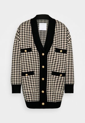 Cardigan lungo in pied de poule nero e bianco con rifiniture nere, sei bottoni dorati e quattro tasche frontali con dettagli di bottoni dorati.