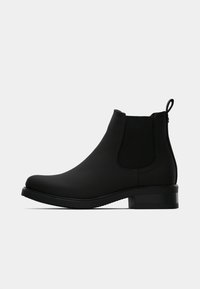 Botine negre până la gleznă cu exterior din cauciuc neted, panouri elastice pe laterale, toc jos bloc și o bandă pe spate pentru a fi ușor de purtat.