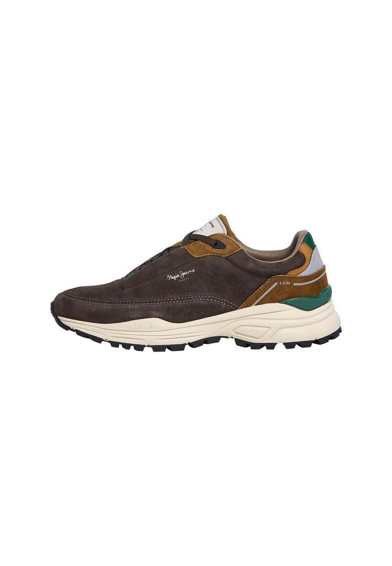 Sneaker in suede marrone scuro con accenti verdi, marroni e crema. Presenta un motivo testurizzato, un design arrotondato e una suola in gomma.