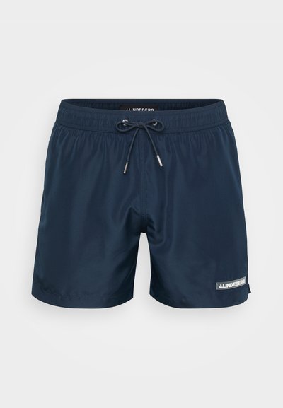 Shorts de bain navy en tissu lisse avec une taille élastique, un cordon de serrage et un patch logo sur le bas droit.