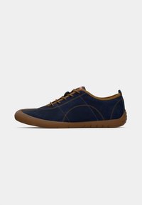 Chaussures en daim bleu marine avec des semelles en caoutchouc marron, bout arrondi, accents cousus et œillets de lacet marron. Design minimaliste avec une texture lisse.