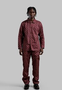 Bordeaux mønstret pyjamas sæt, der indeholder en knaplukket skjorte med en lomme og matchende bukser, lavet af glat stof med et lille printdesign.