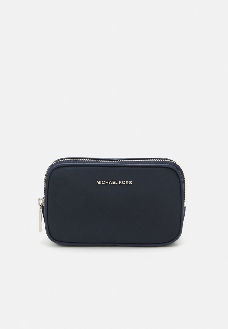 Mørkeblå nylonlomme med en glat tekstur, sølvfarvet lynlås og prægede "MICHAEL KORS" logo på forsiden. Rektangulær form.