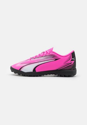 Chaussure de sport Puma en rose vif avec des accents argentés, présentant un design épuré, une tige texturée et une semelle en caoutchouc noir avec des crampons de traction.