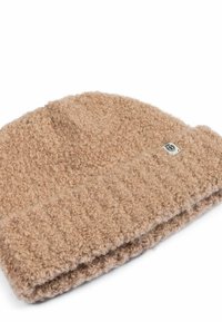 Brown knitted wool beanie with a textured, curly pattern and a small white rectangular tag on the edge.