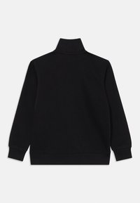 Maglione nero con colletto alto, maniche lunghe e polsini a costine. Realizzato in un tessuto morbido con una texture liscia. Design minimalista.