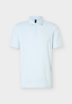 Polo de manga corta azul claro con tapeta de tres botones y cuello, mostrado sobre un fondo blanco liso.