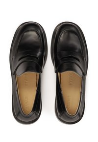 Black leather loafers with a sleek design, rounded toe, cut-out accents, and a smooth finish. Light tan insoles visible inside.