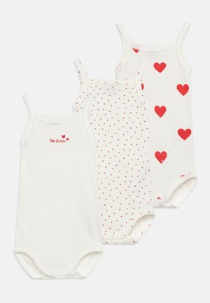 Drie witte katoenen rompertjes met rode accenten: één effen met een hartgrafiek, één met kleine rode hartjes en één met grotere rode hartjes.