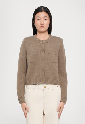 Cardigan taupe raccourci en tissu tricoté avec une texture côtelée, col rond, devant à six boutons et deux poches poitrine.