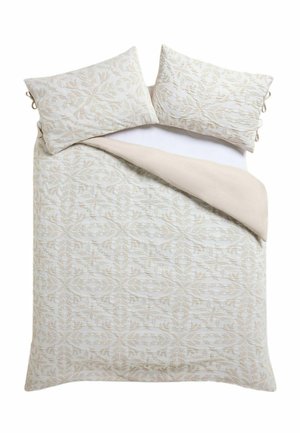 Doppelbett mit cremefarbenem und beigem Bettbezug mit Blumenmuster und passenden Kissen, eine Ecke der Bettdecke zurückgefaltet, um die einfarbige beige Unterseite zu zeigen.