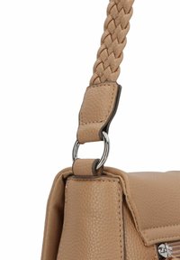 Sac en cuir tan avec une sangle tressée, des accessoires en argent et une finition texturée. Le design à rabat ajoute une apparence structurée.