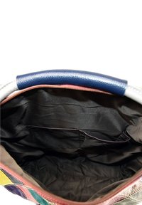 Verschillende kleuren handtas interieur met een marineblauwe handgreep, een gladde zwarte stofvoering en een binnenzak met een donkere rand.