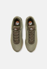 Olive zaļi sporta apavi ar teksturētu sieta augšdaļu, apaļajiem šņorēm un redzamu Air Max logotipu uz iekšzoles. Gumijas zole.