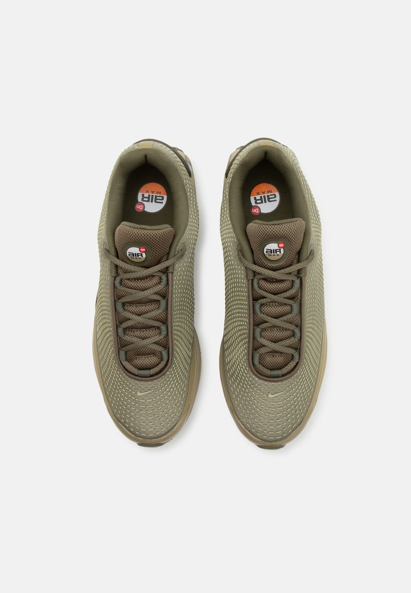 Zapatillas deportivas de color verde oliva con parte superior de malla texturizada, cordones redondos y un logo de Air Max visible en la plantilla. Diseño de suela de goma.