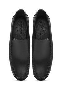 Scarpe slip-on in pelle nera con finitura liscia, punta rotonda e cuciture decorative lungo i bordi. Presentano una soletta perforata.