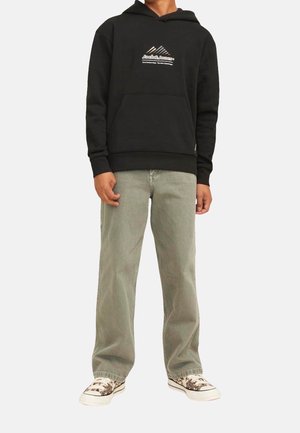 Musta huppari, jossa etutasku ja logo, yhdistetty vaaleanvihreisiin farkkuihin ja kuvioituihin lenkkareihin. Yksinkertainen muotoilu ja rento tyyli.