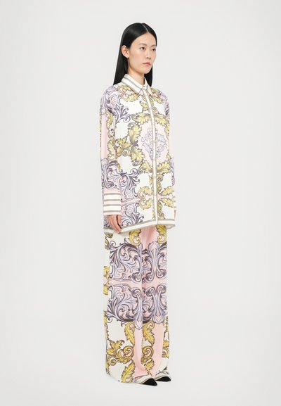 Langemouw overhemd en wijde broek in pastelkleuren met ornate gouden en grijze barokpatronen; heeft een kraag en contrasterende streepaccenten.