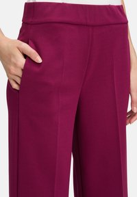 Magenta wijde broek met een gladde textuur, voorzien van een hoge tailleband en zijzakken voor functionaliteit.