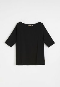 Czarna bluzka z krótkim rękawem, wykonana z miękkiego materiału o luźnym kroju, z szerokim dekoltem i przeszyciem na dole. Posiada małą metkę marki z boku.