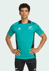 Teal träningsshirt med svarta sidopaneler, med All Blacks-logo och Adidas-märke, i en figurnära design med korta ärmar.
