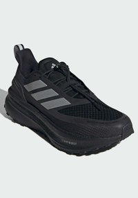 Black athletic shoe featuring a mesh upper, three grey stripes, padded collar, and textured sole with "LIGHTBOOST" branding.