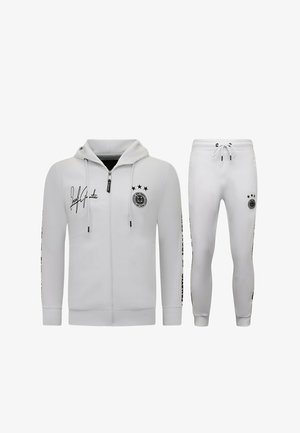 Witte zip-up hoodie en bijpassende jogger met trekkoord, met zwart logo en sterdetails op borst en dij.