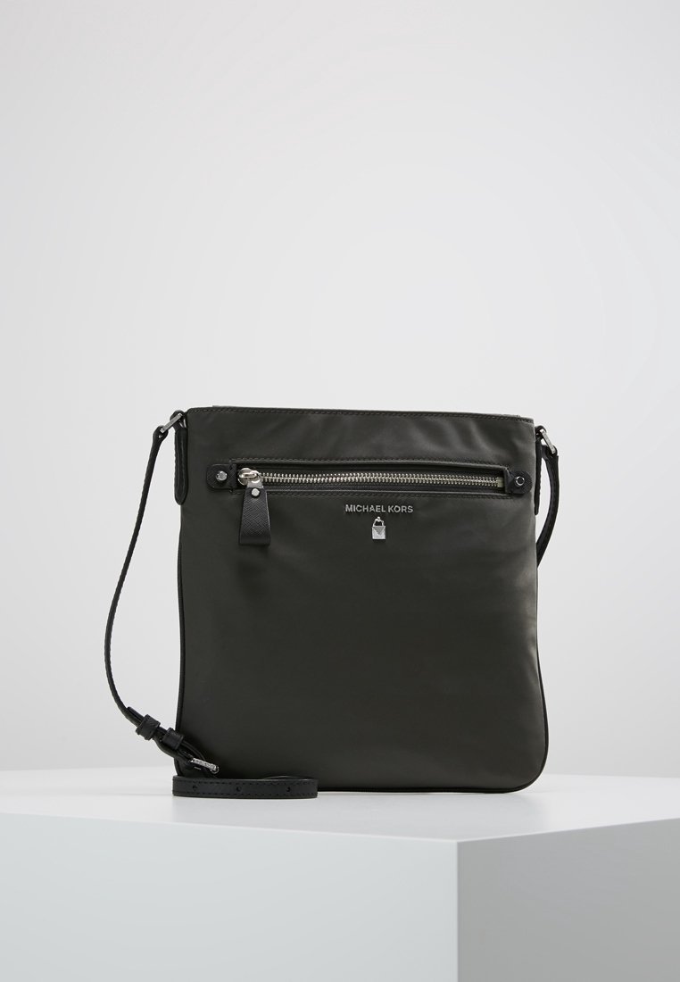 Mørkegrøn læder skuldertaske med justerbar rem, lynlåslomme foran og sølvfarvet hardware med brandlogo. Glat tekstur.