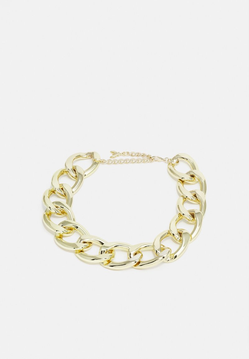 Collier chaîne épaisse en or avec de grands maillons ovales et un fermoir réglable sur un fond clair.